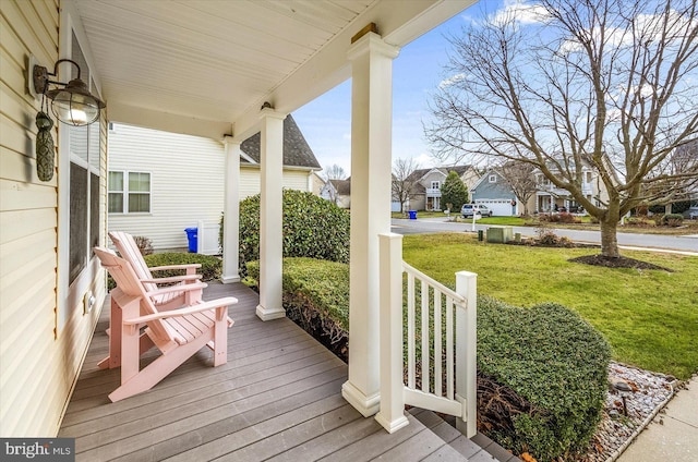 wooden deck featuring a lawn and a porch