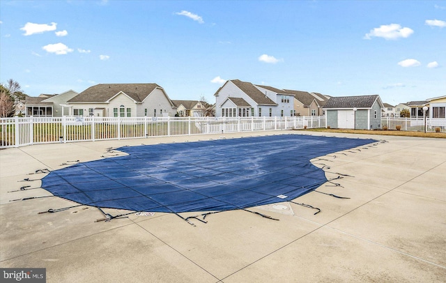 view of swimming pool featuring a storage shed and a patio area