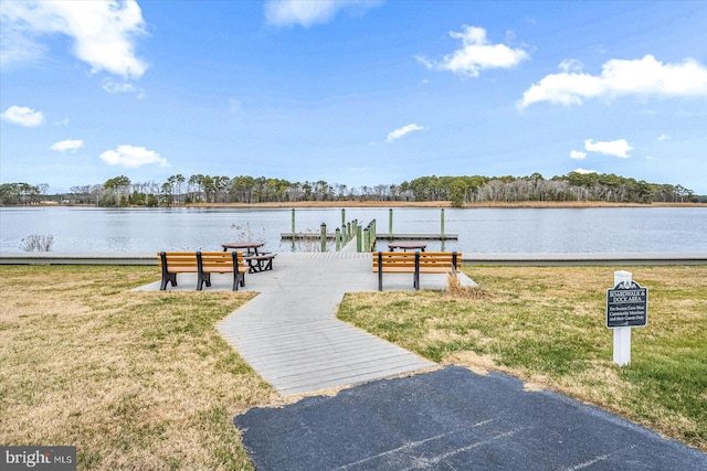 surrounding community featuring a water view, a yard, and a dock