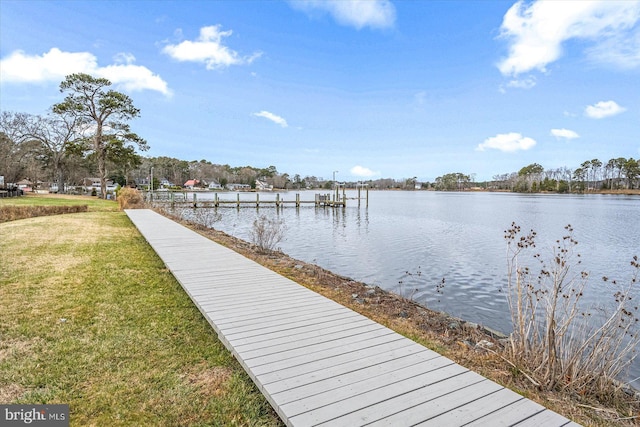 dock area with a lawn and a water view