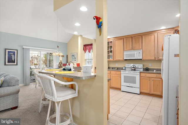 kitchen with white appliances, lofted ceiling, decorative light fixtures, a notable chandelier, and a breakfast bar area