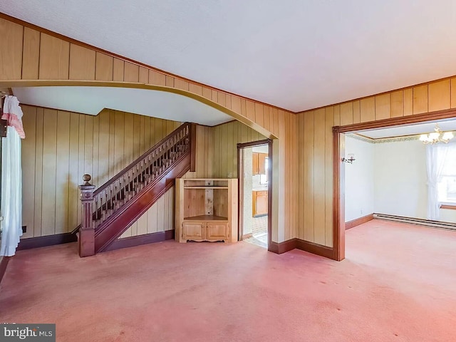 unfurnished living room with carpet flooring, a chandelier, and a baseboard radiator