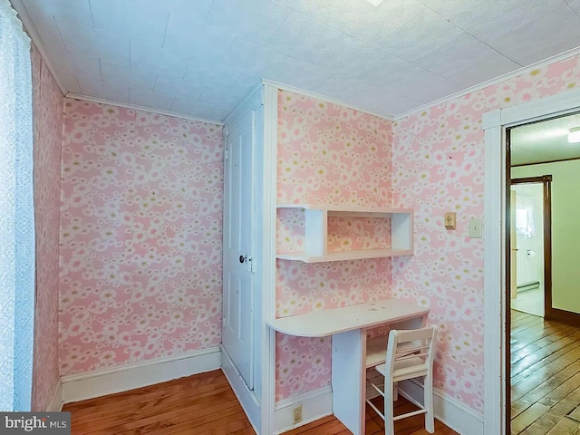 interior space featuring hardwood / wood-style flooring and ornamental molding