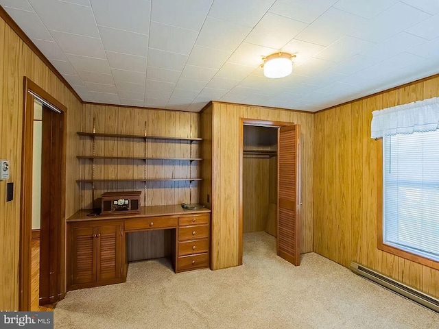 office space featuring light carpet, a baseboard heating unit, and wood walls