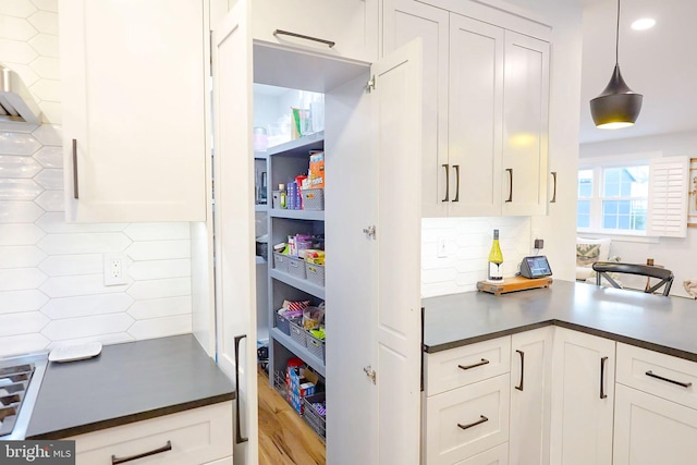 kitchen with decorative light fixtures, white cabinetry, and tasteful backsplash