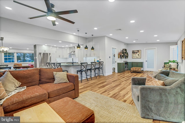 living room with ceiling fan and light hardwood / wood-style flooring