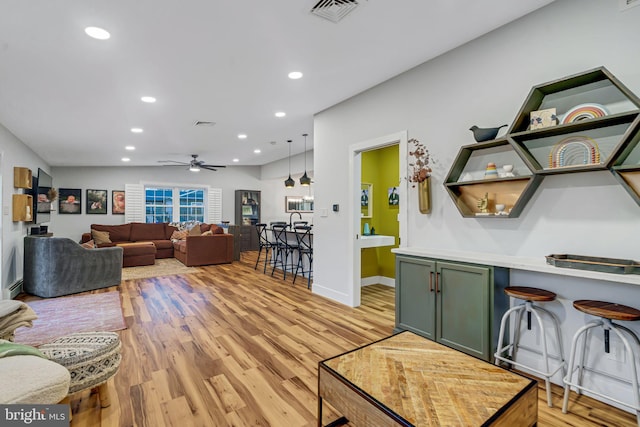 living room featuring light wood-type flooring and ceiling fan