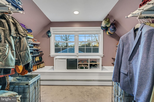 spacious closet featuring light colored carpet, baseboard heating, and vaulted ceiling