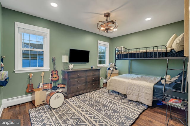 bedroom with dark hardwood / wood-style flooring and baseboard heating