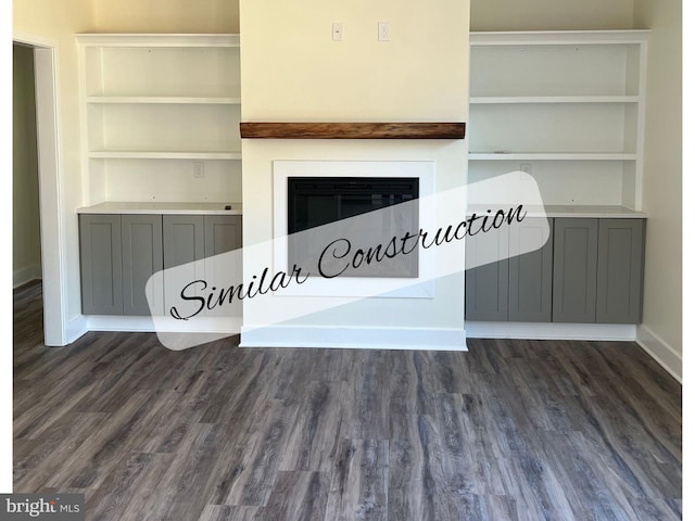 unfurnished living room with dark hardwood / wood-style flooring and built in shelves