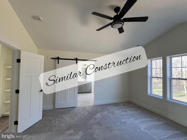 interior space featuring ensuite bathroom, lofted ceiling, and carpet