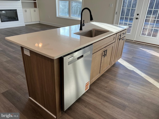 kitchen with dishwasher, a kitchen island with sink, sink, and dark hardwood / wood-style floors