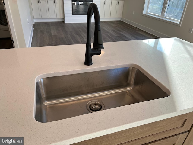 interior details featuring dark hardwood / wood-style flooring, sink, and white cabinets