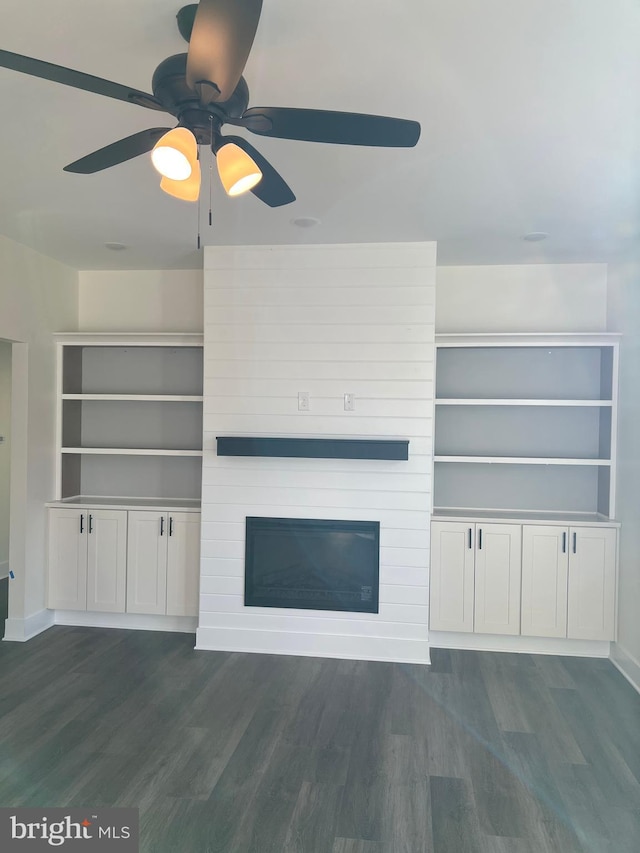 unfurnished living room with a large fireplace and dark hardwood / wood-style flooring