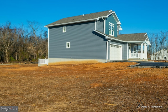 view of home's exterior with a garage and a porch