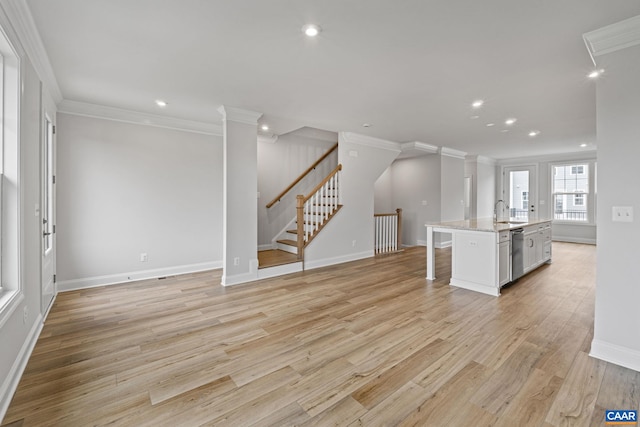 unfurnished living room with sink, crown molding, and light hardwood / wood-style flooring