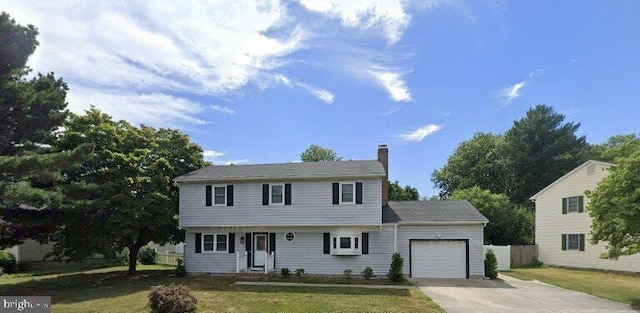 colonial home with a chimney, a front yard, fence, a garage, and driveway