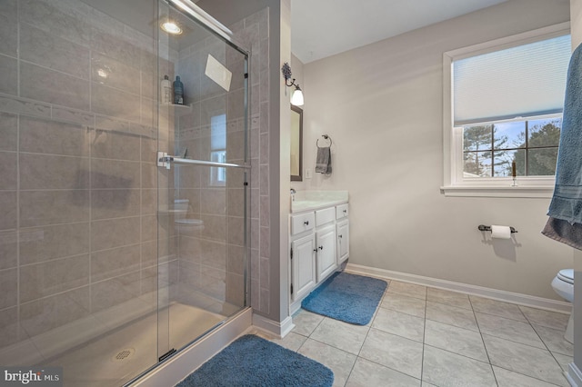 bathroom featuring a stall shower, tile patterned flooring, vanity, and toilet