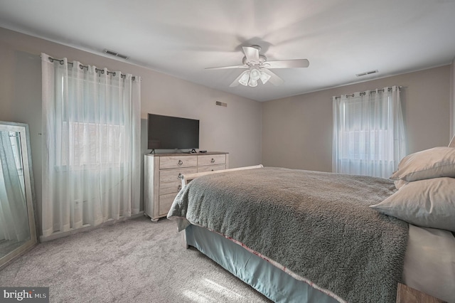 bedroom featuring light colored carpet, visible vents, and ceiling fan