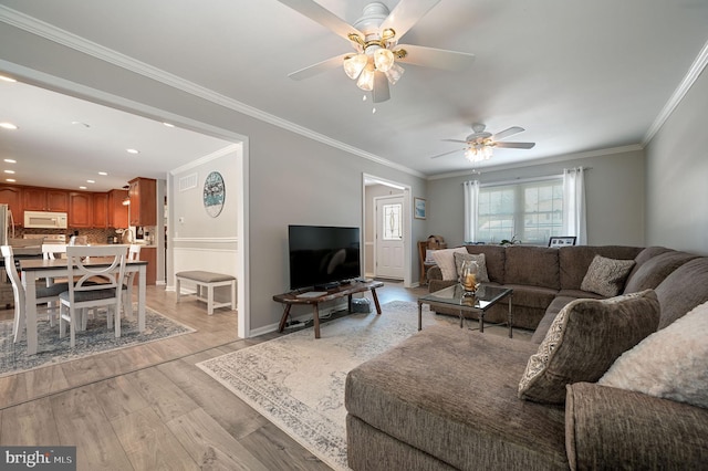 living area featuring baseboards, ornamental molding, recessed lighting, and light wood-style floors