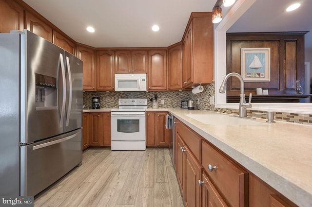 kitchen with appliances with stainless steel finishes, brown cabinets, and a sink