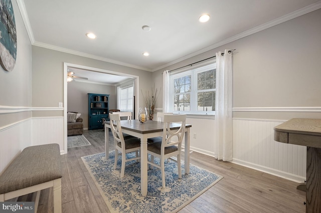 dining room featuring ornamental molding, wood finished floors, and wainscoting