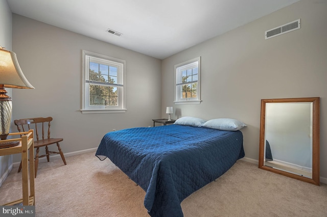 carpeted bedroom with visible vents and baseboards