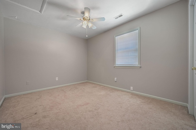 empty room featuring carpet flooring, ceiling fan, visible vents, and baseboards