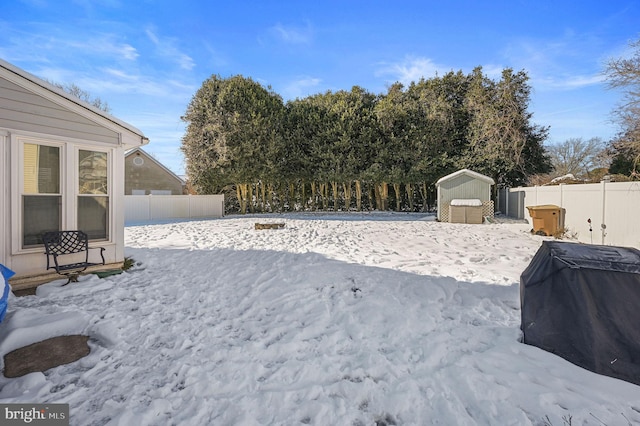 yard covered in snow featuring an outdoor structure and a fenced backyard