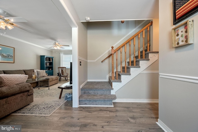 stairs with ceiling fan, wood finished floors, and baseboards