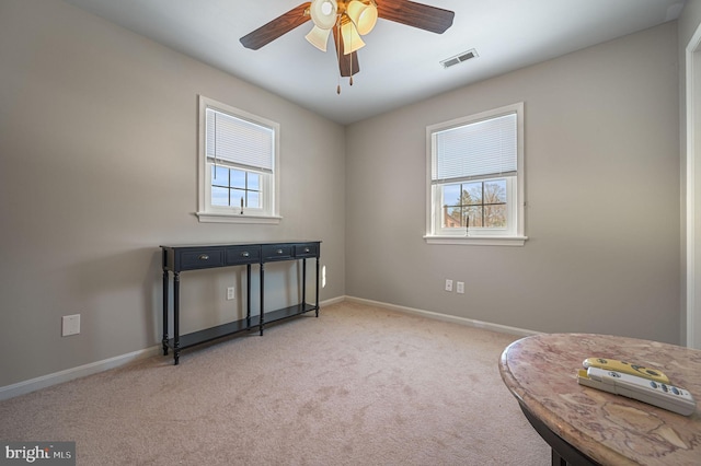 sitting room featuring carpet floors, baseboards, visible vents, and a wealth of natural light