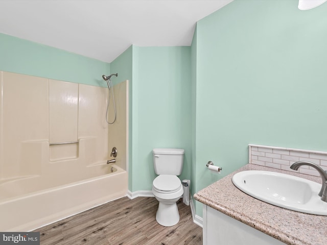 full bathroom featuring tasteful backsplash, vanity, shower / washtub combination, hardwood / wood-style flooring, and toilet