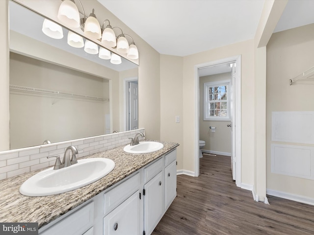 bathroom featuring decorative backsplash, vanity, hardwood / wood-style flooring, and toilet