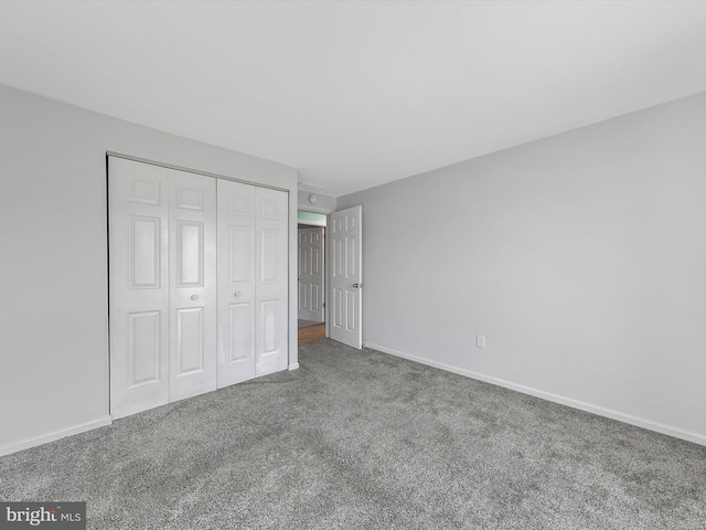 unfurnished bedroom with carpet flooring and a closet