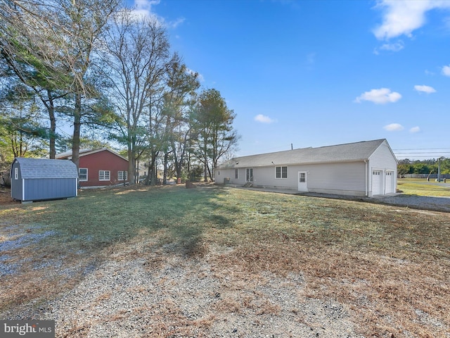 view of yard featuring a garage and a storage shed