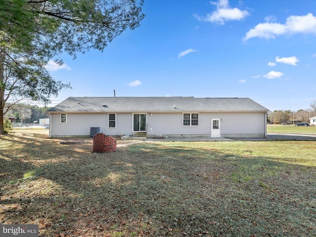 back of house with a yard and central AC