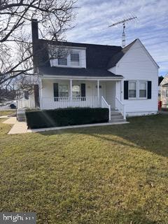 view of front facade featuring covered porch and a front yard