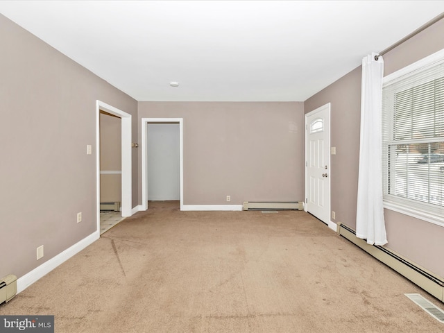 carpeted spare room featuring a baseboard radiator