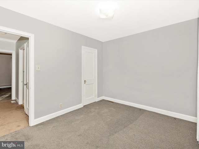 spare room featuring carpet floors and a baseboard heating unit