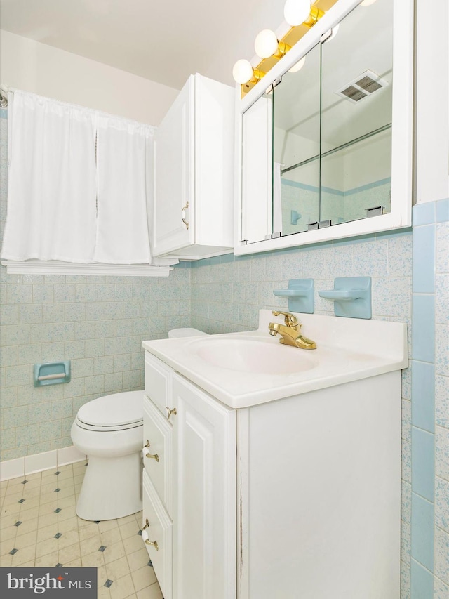 bathroom featuring tile patterned flooring, vanity, toilet, and backsplash