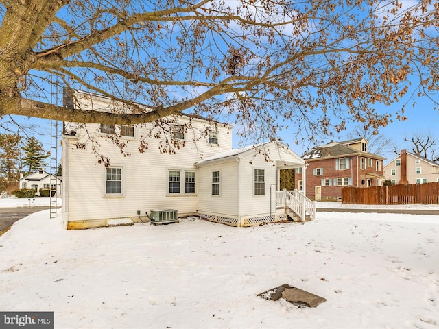 snow covered back of property featuring cooling unit