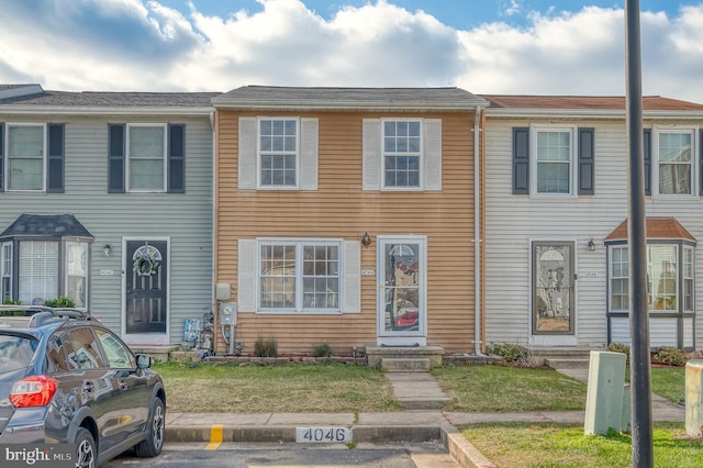 townhome / multi-family property with a front yard