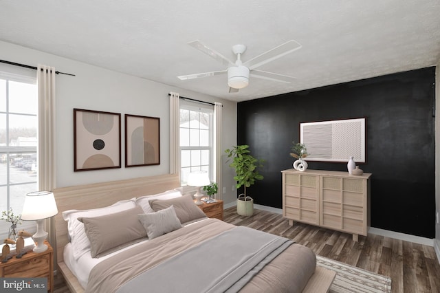 bedroom with ceiling fan and dark hardwood / wood-style flooring