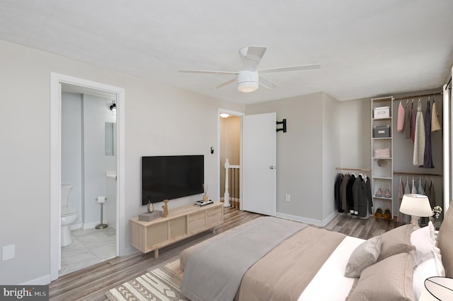 bedroom featuring ceiling fan, wood-type flooring, and ensuite bath