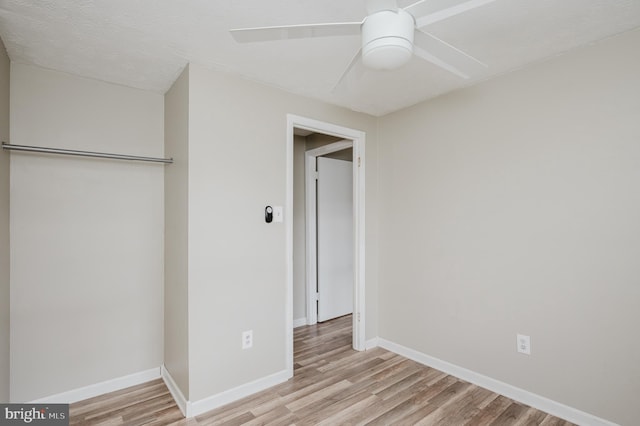 unfurnished bedroom with ceiling fan, a closet, and light wood-type flooring