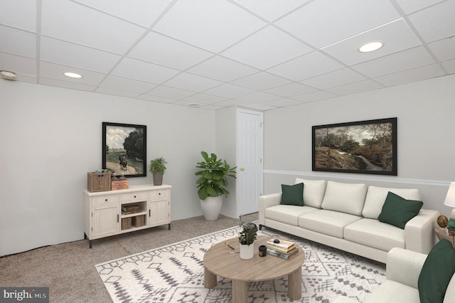 carpeted living room featuring a drop ceiling