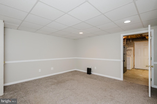 basement with washer / clothes dryer, refrigerator, a drop ceiling, and carpet