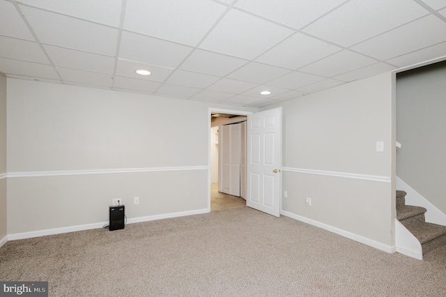 basement featuring carpet floors and a paneled ceiling