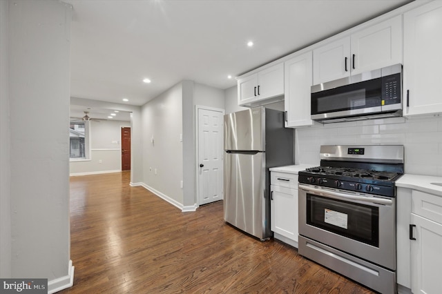 kitchen with white cabinets, stainless steel appliances, tasteful backsplash, and dark hardwood / wood-style floors