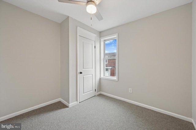 carpeted spare room with ceiling fan